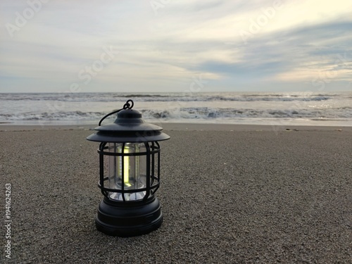 Lantern on beach during sunset Ramadan Kareem concept