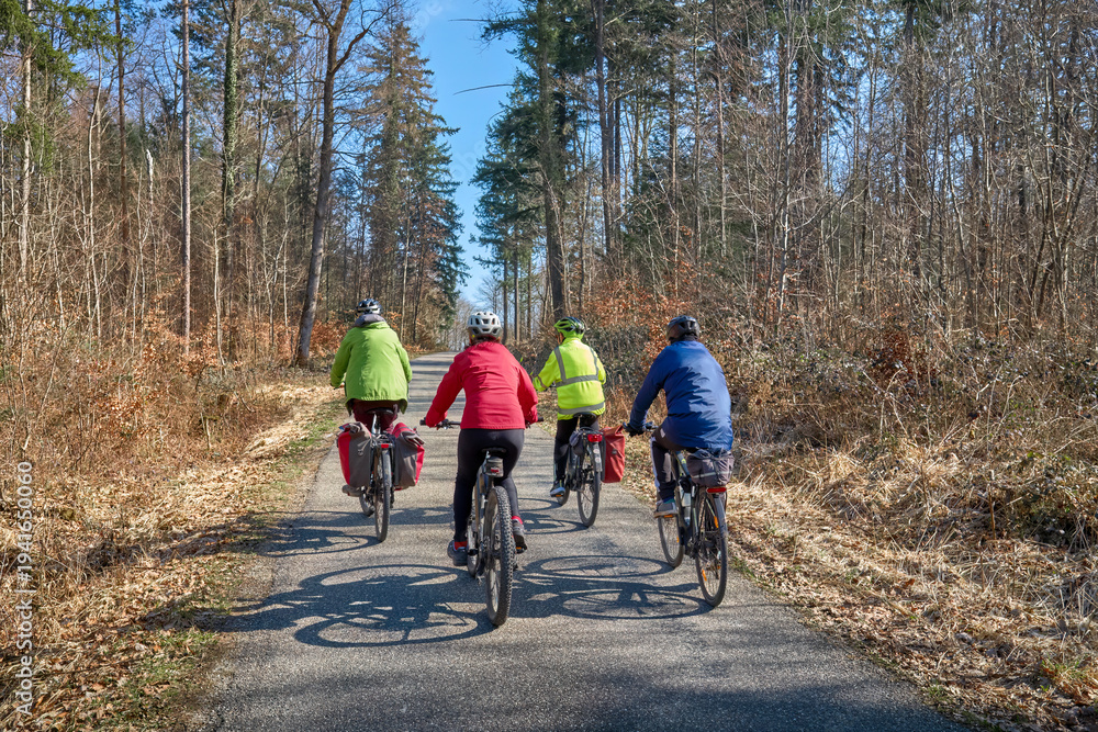 Fototapeta premium Group of active seniors enjoying a bicycle tour on a sunny spring day in the Swabian Forest, Germany. Friends cycling together through nature, promoting healthy lifestyle, recreation, and outdoor