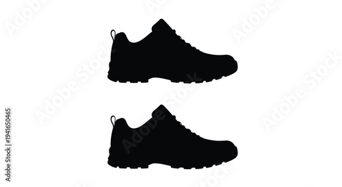 Two black running shoes displayed in a stark silhouette