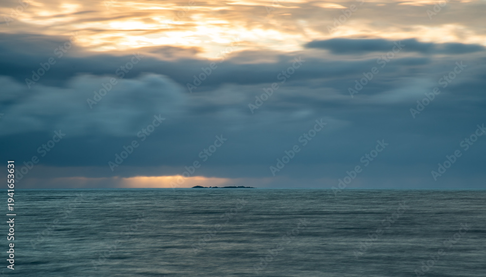 Obraz premium Dramatic seascape of sunset or sunrise sky with storm clouds during morning or evening. Dramatic sunset over the sea with orange clouds and sun with bright sunrays ocean water