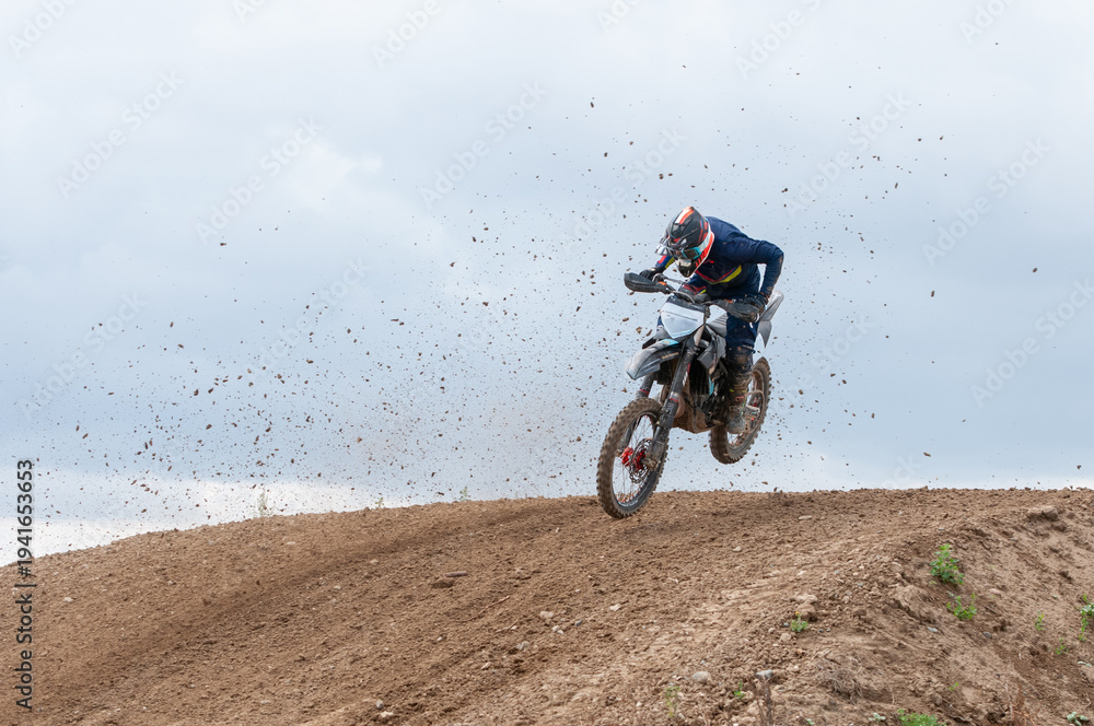 Obraz premium Unrecognized athlete riding a sports motorbike jumping on the air on a motocross race. Fast speed extreme sport.