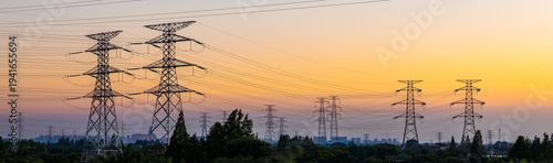 Foto High voltage electricity pylons and transmission lines at sunset