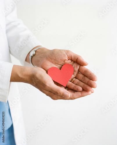 Female Physician Holding Paper Heart in Hands on White Background, Medical Care, Heart Health and Insurance Concept