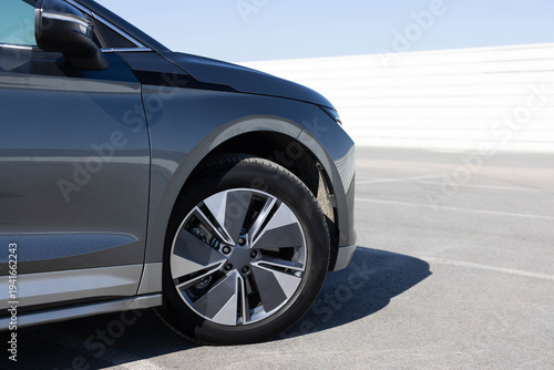 Modern SUV electric car wheel. Close up tires on a road. Detail of car tires on the road. New electric vehicle front wheel. Detail of car tires on the road
