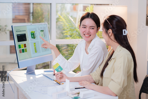 Two asian woman designer using AI artificial intelligence assistant for cosmetic packaging design development, team business marketing planning creative, product design project with AI for idea.