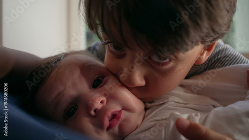 Photography Older brother kissing baby intensely, affectionate yet overwhelming sibling mome