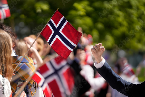 Crowd of people waving Norwegian flags and cheering a national celebration in Norway. Norwegian Constitution Day and national pride, representing Scandinavian culture, patriotism, cultural traditions.