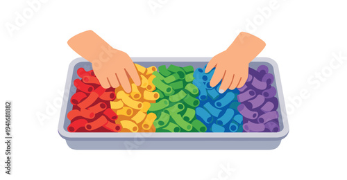 Two small hands reach into a tray full of interlocking toy links arranged in rainbow colors, suggesting a sensory sorting or learning activity for children.