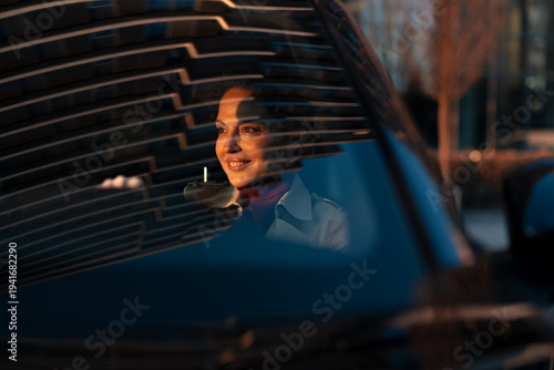 Schilderij op canvas Woman smiling driving car early morning at sunrise