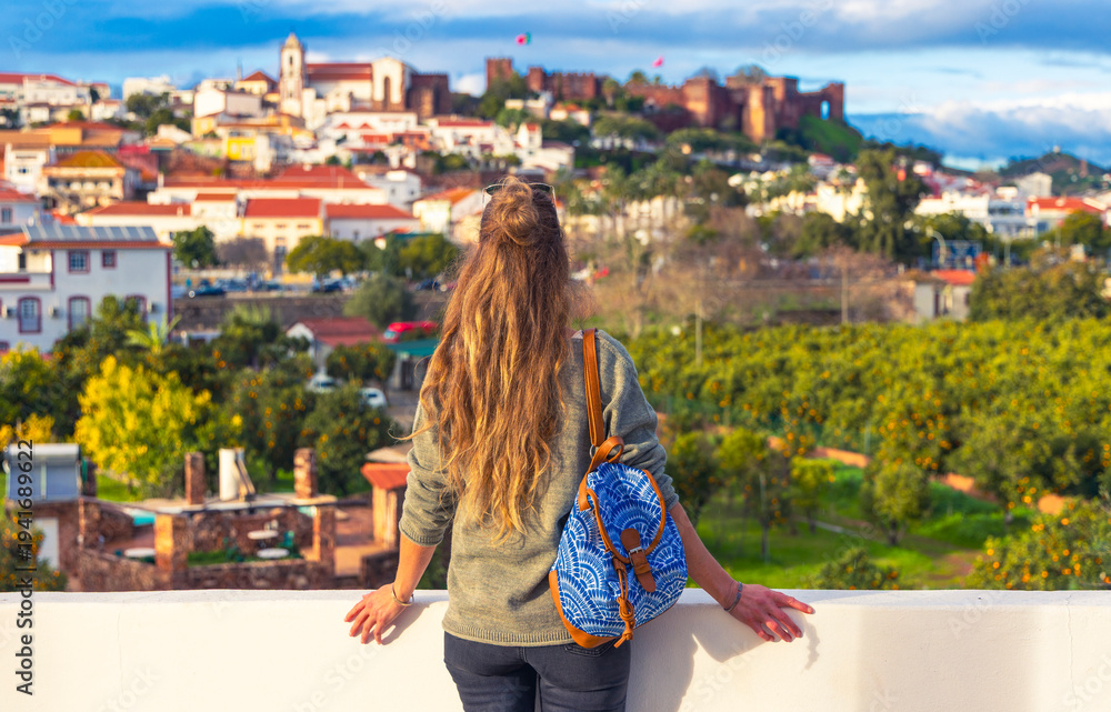 Fototapeta premium woman tourist enjoying panoramic view of Silves city landscape in Algarve, castle and cathedral in Portugal