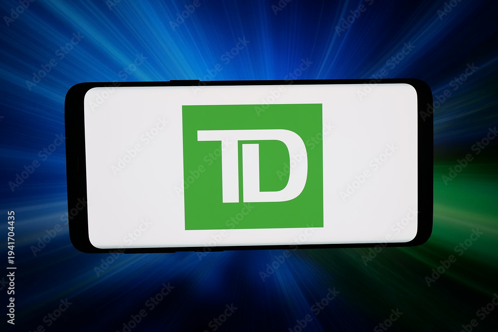 Fototapeta premium Stuttgart, Germany - 03-04-2026: In this photo illustration, the logo of company Toronto-Dominion Bank (TD Bank Group) is displayed on a smartphone in front of abstract background on computer screen.