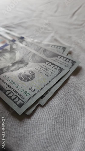 US dollar banknotes are being counted on grey background, closeup wide angle view.