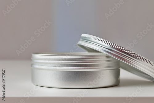 Opened  a gray cosmetic jar with lid