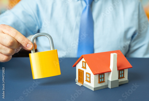 Obraz na plátne A house and a padlock in a man's hand
