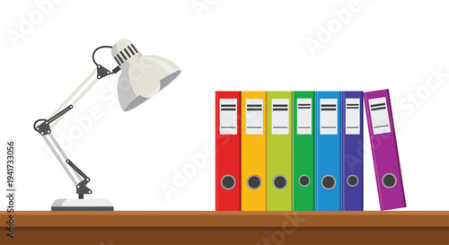 A grey adjustable desk lamp is positioned on a brown wooden surface next to a neat row of seven colorful ring binders against a stark white background.