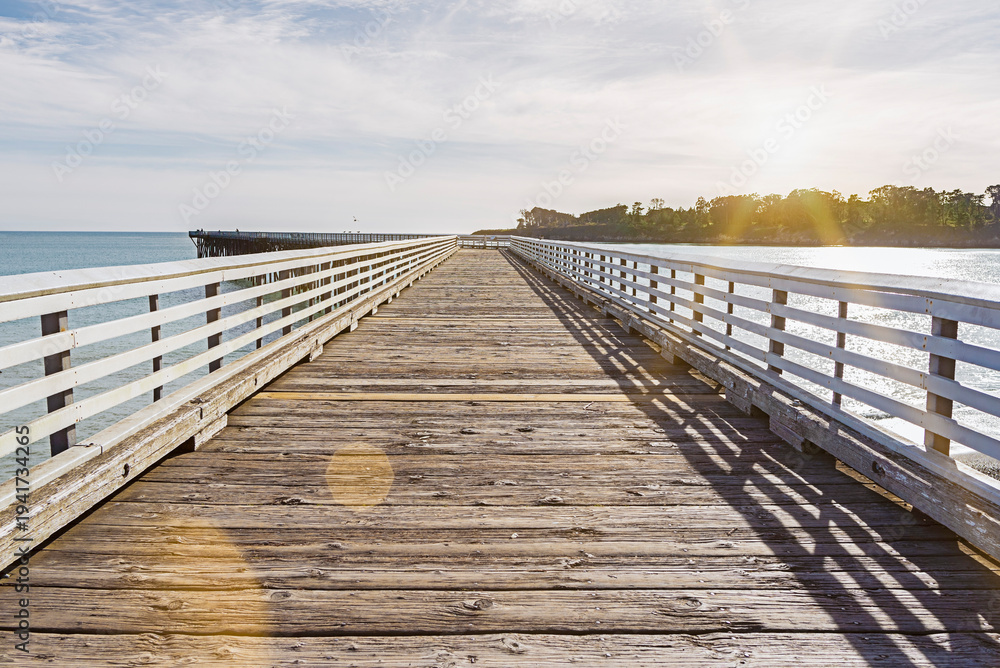 Fototapeta premium Coastal sunset landscape featuring the iconic pier at San Simeon, California