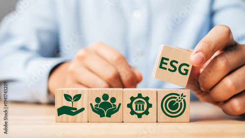 A close-up photograph of wooden building blocks with ESG (Environmental, Social, and Governance) icons on them