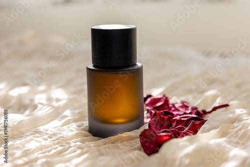 Dried Roses with Black Perfume Bottle on Fabric
