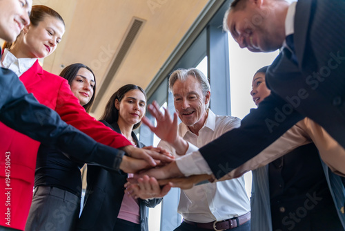 Diverse business team stacking hands together in a circle, showing unity and collaboration