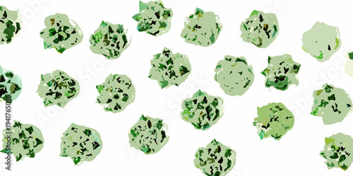 An aerial view of scattered green and dark shapes resembling foliage
