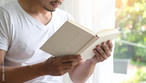 Man Reading a Book by the Window Relaxation and Leisure Activities in the Morning Light Serene Moment of Quiet Time.