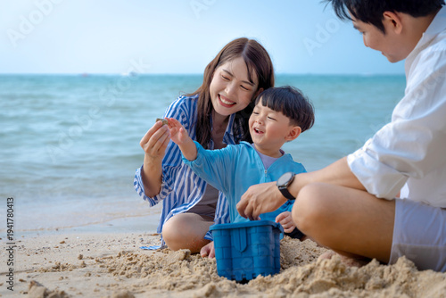 Multigenerational Asian family enjoying summer beach vacation, playing and relaxing together.