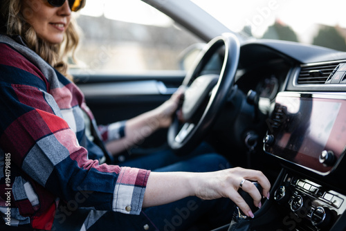 Canvas-taulu Woman driving manual car shifting gears on journey