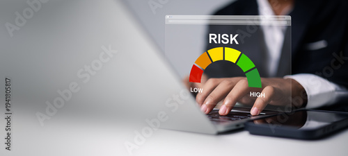Fotografie Businessman hands using laptop with virtual risk assessment gauge meter