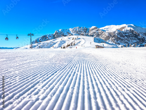 Nassfeld Ski Resort Winter Scene with Skiers, Corduroy Slopes and Sun Rays, Austria