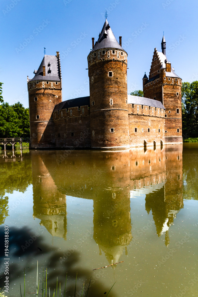 Fototapeta premium Beersel Castle. The outer walls and towers of the medieval castle are reflected in the moat. Beersel Castle, Flemish Brabant, Belgium