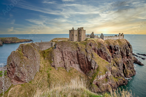 Dunnottar Castle is a medieval castle, now in ruins, perched on a rocky cliff on a headland on the northeast coast of Scotland. United Kingdom