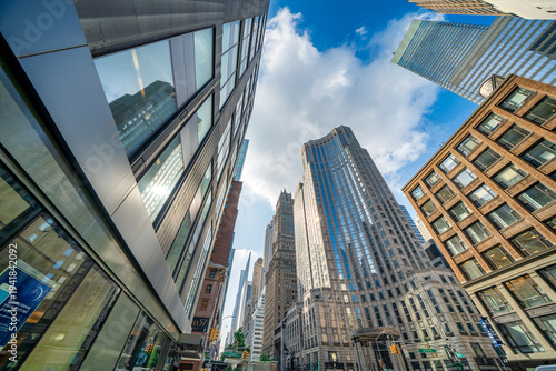 Fotografie Skyward view of Manhattan skyscrapers against dramatic blue sky