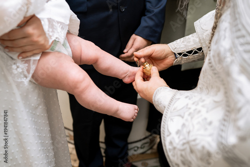 Slika na platnu Orthodox priest anointing newborn baby foot with holy oil during baptism ceremon