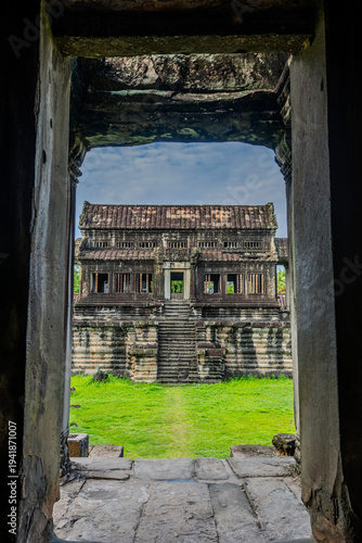Ancient stone gallery of Angkor Wat temple framed by doorway