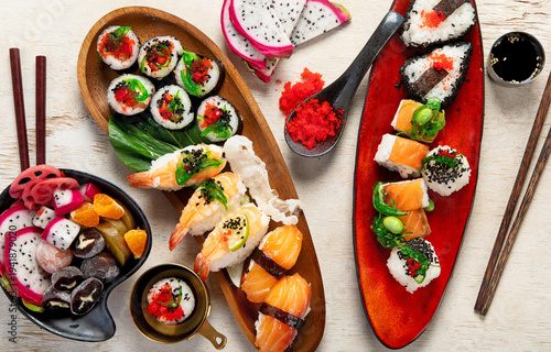 A table with Asian food, sushi, rolls, desserts.