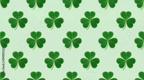 Seamless pattern of vibrant green shamrock leaves against a soft pastel green background, perfect for St