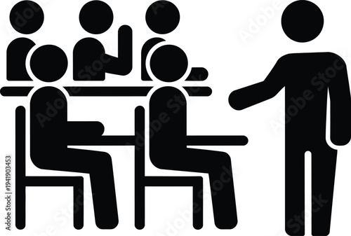 A group of people sitting around a table with one person standing and gesturing.