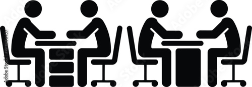 Four people sitting at a table in a meeting room having a discussion.