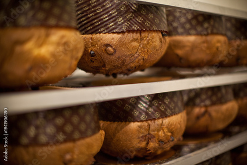 Foto Freshly baked panettone hanging upside down after baking to maintain its tall domed shape, a traditional Italian pastry technique used to preserve the soft airy structure