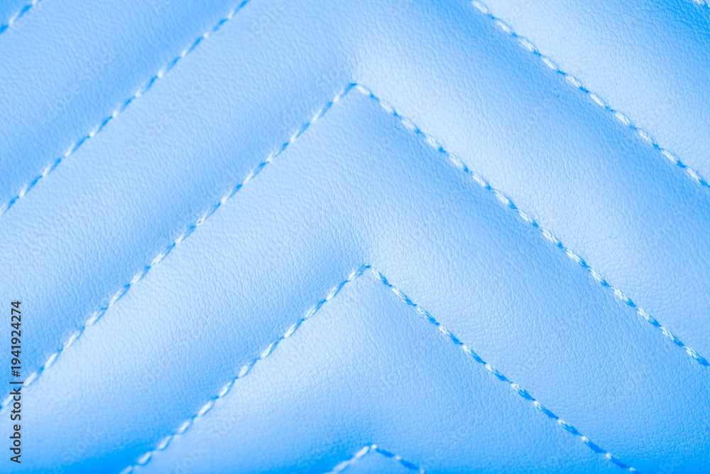 Obraz premium Close up of smooth vibrant light blue quilted material showcasing a delicate zigzag stitch pattern