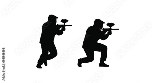 Two paintball players in action poses a dramatic silhouette