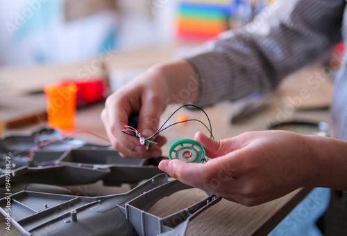 Close-Up of Student Hands Assembling Electronic Components for Robotics Project