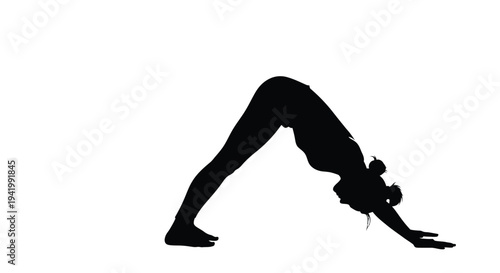 Woman performing downward facing dog yoga pose a striking silhouette