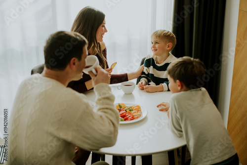 Family enjoys breakfast at home with fruits and coffee in the morning sunlight