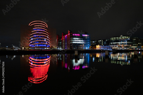 Canvas Print Illuminated modern architecture of city buildings reflected in the calm waters of the River Liffey at night in Dublin Ireland