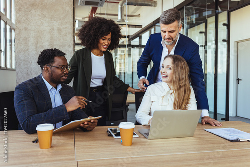 Business Team Meeting With Colleagues Collaborating Around Laptop in Modern Office Workspace