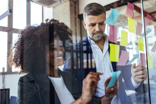 Business Colleagues Collaborating With Colorful Sticky Notes During Creative Office Brainstorming Meeting