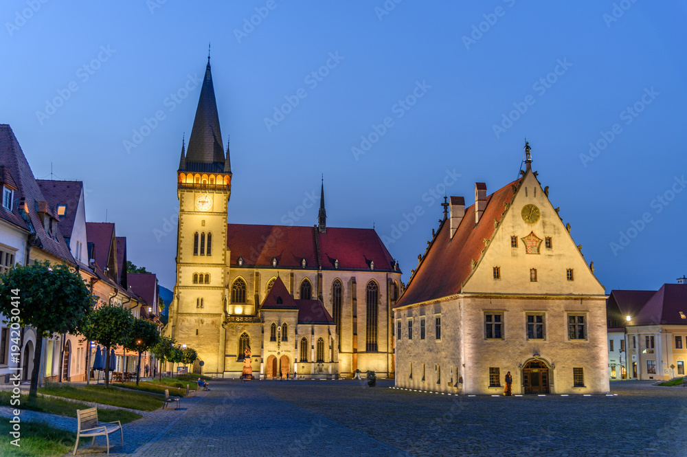 Fototapeta premium Bardejov town hall and church illuminated at night, Slovakia