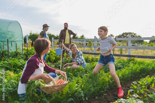 Happy farmers or gardeners working outdoors at community farm.