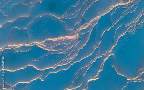 Aerial drone view of the famous Pamukkale travertines and thermal pools in Denizli, Turkey, showing the white calcium terraces, natural formations, and scenic landscape from above.